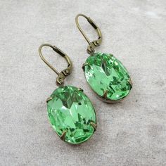 "Vintage European glass jewels are featured in these beautiful earrings. Jewel color is a lovely peridot green in an 18x13mm oval shape. They have been hand set into antiqued brass settings and dangle from matching lever back ear wires. Total measurement is 1.5\". All items come gift boxed in my signature gift wrapping and ready to give as a gift or a special treat for yourself! Thanks for visiting my shop and I hope you'll stop again as new items will be added regularly! You can return to my sh New Castle, Jewel Colors, Peridot Green, Vintage European, Green Crystal, Green Earrings, European Vintage, Earrings Vintage, Spring Green