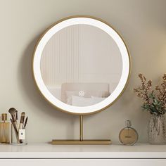 a round mirror sitting on top of a white dresser