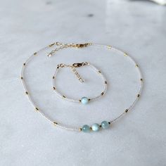 These rare green moonstone gemstones will transport you to the dreamy green waters of a tropical island. They are paired with semi-transparent pearlescent glass beads for the ultimate island look! These are some of my favorite gemstones because the milky aqua color is just too good to be true. SHOP THE MATCHING BRACELET! Moonstone is one of my favorite gemstones, not just because of its beauty, but because of all the properties it possesses. Known as the stone of inner wisdom, moonstone is great Green Moonstone Jewelry With Natural Stones, Handmade White Jade Beaded Necklaces, White Jade Beaded Necklace With Gemstone Beads, White Jade Beaded Jewelry, White Beaded Jade Jewelry, White Amazonite Jewelry With Natural Stones, White Amazonite For Jewelry Making, Handmade Minimalist Amazonite Jewelry, Aquamarine Round Beads Jewelry With Natural Stones