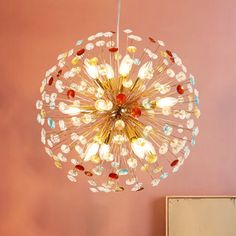 a chandelier hanging from the ceiling in a room with pink walls and furniture