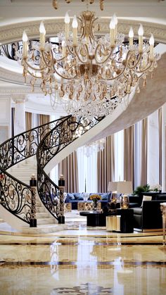 an elegant living room with chandelier and couches