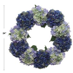 a wreath with blue and green flowers is shown in front of a white background for measurements