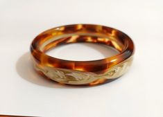 Spectacular bracelet, vintage 70's celluloid bracelet, galatite tortoiseshell tones. New unused stock from Berlin with beautiful design. It measures 2 cm wide and 7 in diameter. Combined shipping for multiples purchases! Elegant Tortoiseshell Bangle Jewelry, Elegant Bakelite Bangle As A Gift, Elegant Bakelite Bangle As Gift, Elegant Bakelite Bracelet Jewelry, Elegant Bakelite Bracelet, Brown Bakelite Bangle Bracelet, Elegant Adjustable Tortoiseshell Bracelets, Elegant Bakelite Bracelets As A Gift, Elegant Bakelite Bracelets For Gift