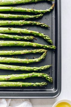 asparagus spears on a baking sheet ready to be cooked with butter and seasoning