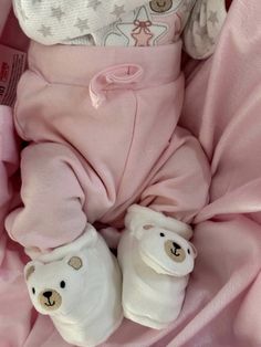 a teddy bear laying on top of a pink blanket