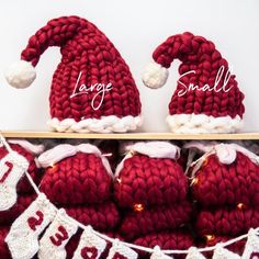 knitted santa hats and stockings are displayed on a shelf with name tags hanging from it