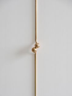 a white wall with a gold handle on it