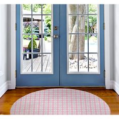 a blue front door with two windows and a rug on the floor next to it