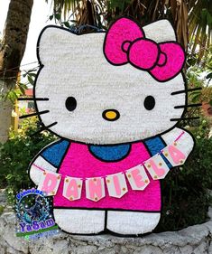 a hello kitty sign is shown in front of a tree