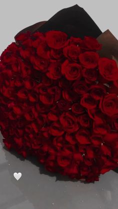 a person holding a large bouquet of red roses