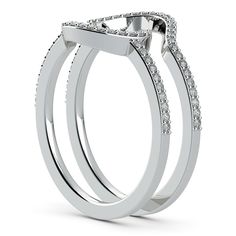 two white gold wedding rings with diamonds on each side and an oval shaped center stone in the middle