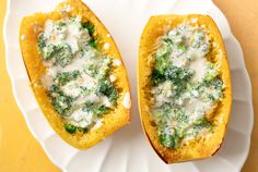 two stuffed squash halves with broccoli and cheese on them sitting on a white plate