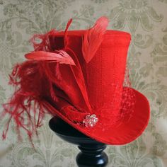 This striking yet elegant burlesque mini top hat is covered with beautiful bright red silk shantung. It is embellished with matching red veil, a luxurious spray of curled ostrich plums and a sparkling flower shaped rhinestone button. Also available in white,black and ivory here : https://www.etsy.com/shop/BizarreNoir?ref=seller-platform-mcnav&section_id=14329940 If you're interested in another color, please, send me a message to talk about your options. This mini top hat is fully lined with Vintage Party Top Hat, Vintage Fitted Top Hat For Party, Red Tall Crown Costume Hat For Party, Vintage Mini Hats With Feathers For Party, Fitted Party Top Hat With Feathers, Fitted Top Hat With Feathers For Party, Fitted Feathered Top Hat For Party, Wedding Top Hat For Halloween, Fitted Mini Hats With Short Brim For Carnival