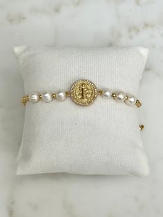 This St. Benedict medal adjustable bracelet is made of the following:  - 8mm pearl beads - 2mm gold beads - The gold Saint Benedict Medal is approximately 1-inch  - Adjustable woven cord Stackable stretch bracelets are a fun and stylish way to express your faith! Featuring the Saint Benedict medal, this bracelet offers powerful spiritual protection against temptation and evil. Looks great stacked with other bracelets from our shop! ✨ Resizable Spiritual Rosary Bracelet Gift, Spiritual Resizable Rosary Bracelet Gift, Adjustable Spiritual Rosary Bracelet For Mother's Day, Spiritual Friendship Bracelets For Mother's Day, Adjustable Spiritual Pearl Bracelet For Gift, Saint Benedict Medal, St Benedict Medal, Benedict Medal, Saint Benedict