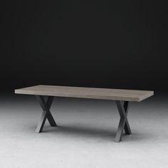 a wooden table sitting on top of a white floor in front of a black wall