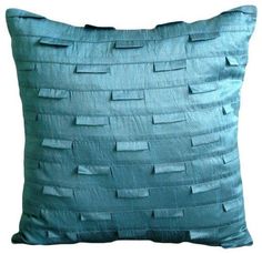 a blue pillow that has been made out of strips of fabric on the front and back