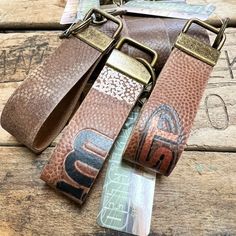 a pair of brown leather straps on top of a wooden table next to an empty wallet