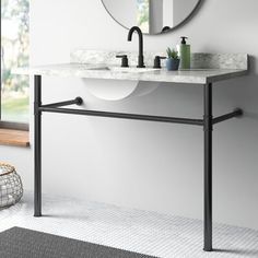 a white sink sitting under a mirror next to a wall mounted faucet in a bathroom