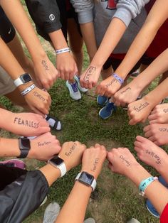 a group of people holding their hands together in a circle with the words fearless written on them