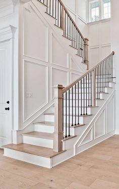 a staircase with white walls and wooden floors