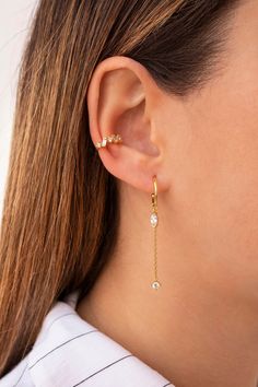 The Emile are open hoop earrings with a dangling chain with 2 cubic zirconias, one of them is marquise-cut and the other round-cut. These dainty, modern, minimalist style earrings can be easily combined with other earrings. Perfect for a gift! Features: * Total length: 55 mm. * Inner diameter hoop: 11 mm. * They are sold in singles and pairs. Both options are available on the dropdown menu. * All of our jewelry is made of sterling silver (925 mm), and our gold jewelry is gold plated in 18K gold. Cubic Zirconia Dangle Ear Cuff, Marquise Earrings, Drop Hoop Earrings, Modern Minimalist Style, Open Hoop Earrings, Style Earrings, Marquise Cut, Jewelry Earrings Hoops, Minimalist Style