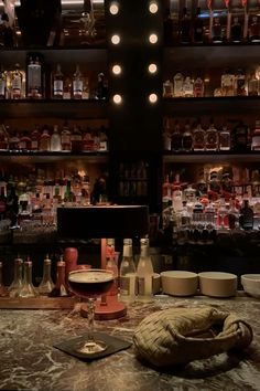 the bar has many bottles and glasses on it, along with an old glove sitting on the counter