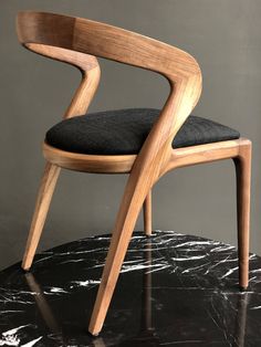 a wooden chair sitting on top of a black marble table