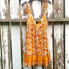 Orange Floral Dress New Without Tags. I Washed It And Bought For Self But It Did Not Fit. Floral Of Zinnias And Maybe Daffodil Like. Bohemian And Like An Indian Print Super Pretty Regular Price $69 Has A Slip With It Is 100% Rayon Wash And Cold Water And Do Not Tumble Dry Treat As A Delicate. The Floral Leaves Are Kind Of A Green Yellow I’m In Love With This Dress, It Has A Zipper In The Back. Flat Lay Pit To Pit Is Approximately 17 Inch. Waist Flat Lay Is 15 Inch. From Where The Strap Starts To Yellow Boho Dress With Floral Print For Vacation, Yellow Casual Boho Beach Dress, Casual Yellow Boho Beach Dress, Casual Yellow Boho Print Dress, Casual Yellow Boho Dress For Vacation, Orange Boho Print Sundress, Yellow Bohemian Mini Dress For Summer, Yellow V-neck Boho Dress For Spring, Mustard Floral Print Summer Dress