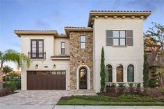 a two story house with brown garage doors