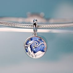 This is charm only, bracelets are sold separately. Experience the allure of Van Gogh's iconic "Starry Night" every day with this exquisite dangle charm. Featuring a stunning blue sky and a silhouette landscape design, this charm is the perfect addition to any bracelet or gift for a loved one. Don't miss out on the chance to own this unique piece inspired by one of the most famous paintings in the world! Materials: 925 sterling silverFinish: platinum plate, enamelDimensions: 0.85 x 0.51 inHole size: 0.18 in Jewelry Care: See more information about how to care for your jewelry here. Shipping Policy: Orders will be shipped within 1-3 business days. Economy shipping will take 7-14 days to arrive and standard shipping is 1- 4 days for U.S. orders. International shipping time is depended on the Sterling Silver Charm Necklace With Removable Charms, Sterling Silver Charm Necklaces With Removable Charms, Sterling Silver Jewelry With Removable Round Charms, Blue Pendant Jewelry With Dangling Charms, Silver Star Charm Celestial, Silver Celestial Star Charm, Silver Star Charm Celestial Charms, Silver Star Charm With Celestial Style, Celestial Sterling Silver Jewelry With Dangling Charms