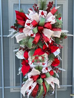 a red and white christmas wreath hanging on the side of a metal door with snowflakes