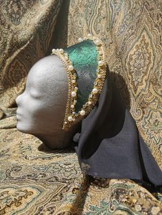 Ready made French Hood made from Jacquard in green with a beautiful sheen, decorated with a golden lace, a petite old gold lace, white acrylic pearls in two sizes and chrystal glass beads, which are all sewn on and not glued.  The Hood has a sewn in circlet and ties for you to make sure it stays on your head.  The base of this hood is an acrylic foil which stays in shape, even in rain and is very flexible. Comes with a black chiffon veil which is attached to the back. Ready made. Traditional Green Headpiece For Parties, Elegant Gold Cap Costume Headpiece, Elegant Gold Cap Costume Hat, Chiffon Veil, Green French, Golden Lace, Anne Boleyn, Black Chiffon, Gold Lace