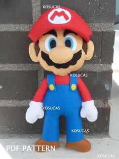 a stuffed mario is standing next to a brick wall