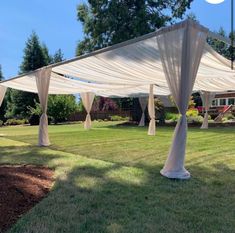 an outdoor area with white drapes and grass