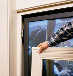 a man holding onto the side of a window