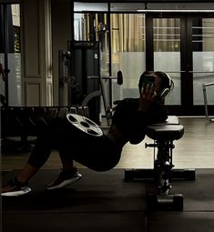 a man is doing push ups on a bench in the gym while looking at his cell phone