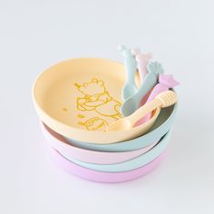 three bowls with toothbrushes in them sitting next to each other on a white surface