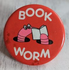 a red book worm button sitting on top of a white table