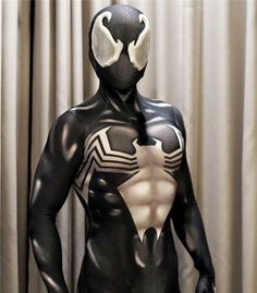 a man dressed in black and white is standing with his hands on his hips while wearing a spider - man costume