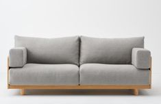 a gray couch sitting on top of a wooden frame