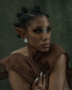 a woman with dark makeup and silver jewelry