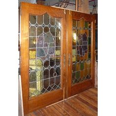 two wooden doors with stained glass panels on the front and back sides, in a room