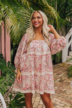 - Embrace the boho spirit with this dreamy dress! - Lined material with an abstract floral print featuring reds and pinks - An elastic scoop neckline - Loose ¾ length sleeves with drawstring closure cuffs featuring tassel accents - Crochet detail - Hidden side pockets - A flowy silhouette that ends in a mini dress length hemline Bohemian Pink 3/4 Sleeve Dress, Bohemian Pink Dress With 3/4 Sleeves, Bohemian Red Floral Beach Dress, Red Bohemian Floral Dress, Red Bohemian Floral Dress For Spring, Bohemian Red Floral Dress For Spring, Red Bohemian Floral Dress For The Beach, Pink Floral Print Dress With 3/4 Sleeves, Pink Floral Print Dresses With 3/4 Sleeve