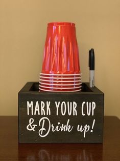 a cup and some cups on a table with marker writing that says, mark your cup & drink up