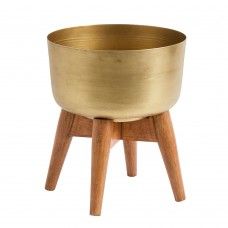 a gold metal bowl sitting on top of a wooden stand