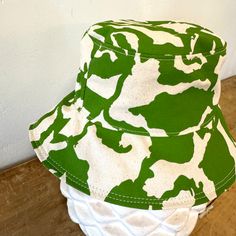 The perfect lightweight bucket hat for sunny spring and summer days! Now available in two sizes (Small/Medium & Large) since we had some issues with these not be consistent last season. Print: 1 color screen print Size: Small/Medium 21-22.5 inches, Large 22.5-23 inches (inside circumference) Material: Cotton, Cotton Canvas Lining Care: Hand Wash Cold. Hang or Lay Flat to Dry. Do not dry in the dryer. Green Cotton Bucket Hat For Outdoor, Green Cotton Outdoor Bucket Hat, Fun Summer Outdoor Bucket Hat, Cotton Bucket Hat With Uv Protection For Spring, Summer Bucket Hat For Everyday Wear, Summer Hats One Size Fits Most For Everyday, Lightweight Bucket Hat For Everyday Spring Use, Lightweight Spring Bucket Hat For Everyday, Trendy Summer Outdoor Bucket Hat