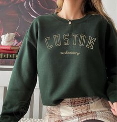 * Your custom text embroidered on super soft and comfortable 50/50 cotton/poly sweatshirt. * Sizes are in Unisex/Men's sizing and runs normal. * Size charts shows the sweatshirt measurement when it is laid flat. * We DO NOT send mockups for this item.  If you have to have a mockup, please Zelle or Venmo $15 to info@camelsota.com with your order number and message to let me know.  Your order processing time will increase by 3-5 business days. Embroidered Logo Sweatshirt For College In Winter, Green Sweatshirt With Letter Embroidery For Streetwear, Green Letter Embroidery Sweatshirt For Streetwear, Sporty Embroidered Crew Sweatshirt, Green Sporty Sweatshirt With Embroidered Graphics, Green Embroidered Sporty Sweatshirt, Sporty Crew Neck Hoodie With Custom Embroidery, Crew Sweatshirt With Embroidered Logo For Winter, College Winter Sweater With Embroidered Graphics