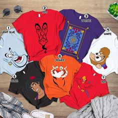 an assortment of disney t - shirts on a wooden floor with other items around them