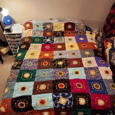 a bed with a multicolored quilt on it