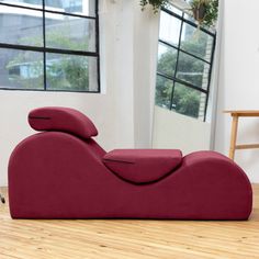 a red couch sitting on top of a wooden floor